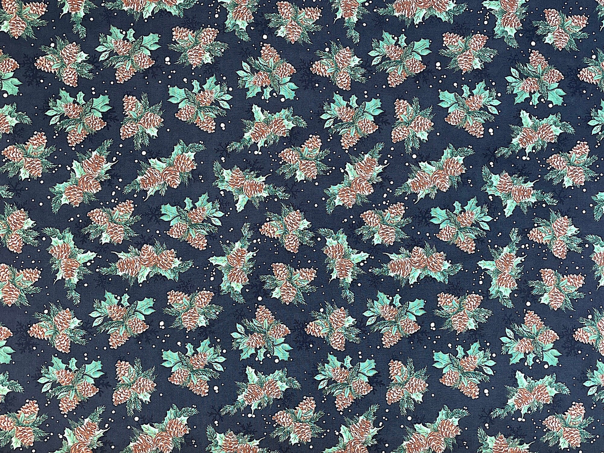 This black cotton fabric is covered with bunches of pinecones and leaves. This fabric is part of the Winter Forest collection by Wilmington Prints.