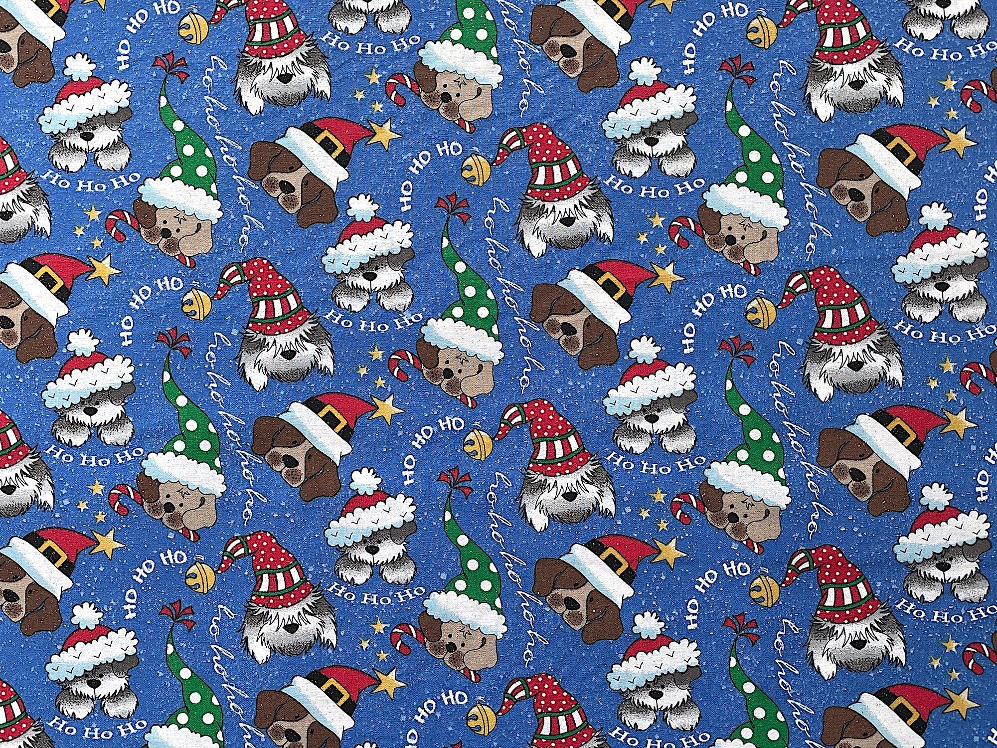 This fabric is called Ho Ho Pups glitter and is covered with dogs wearing Christmas hats. The blue background also has bells and the words Ho Ho Ho and glitter throughout.