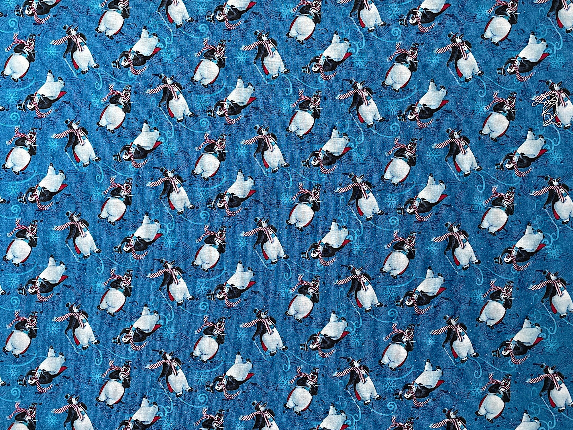 This penguin fabric is part of the 12 Days of Christmas collection designed by Sue Ellen Brown. This blue fabric features tossed penguins. The penguins are playing music