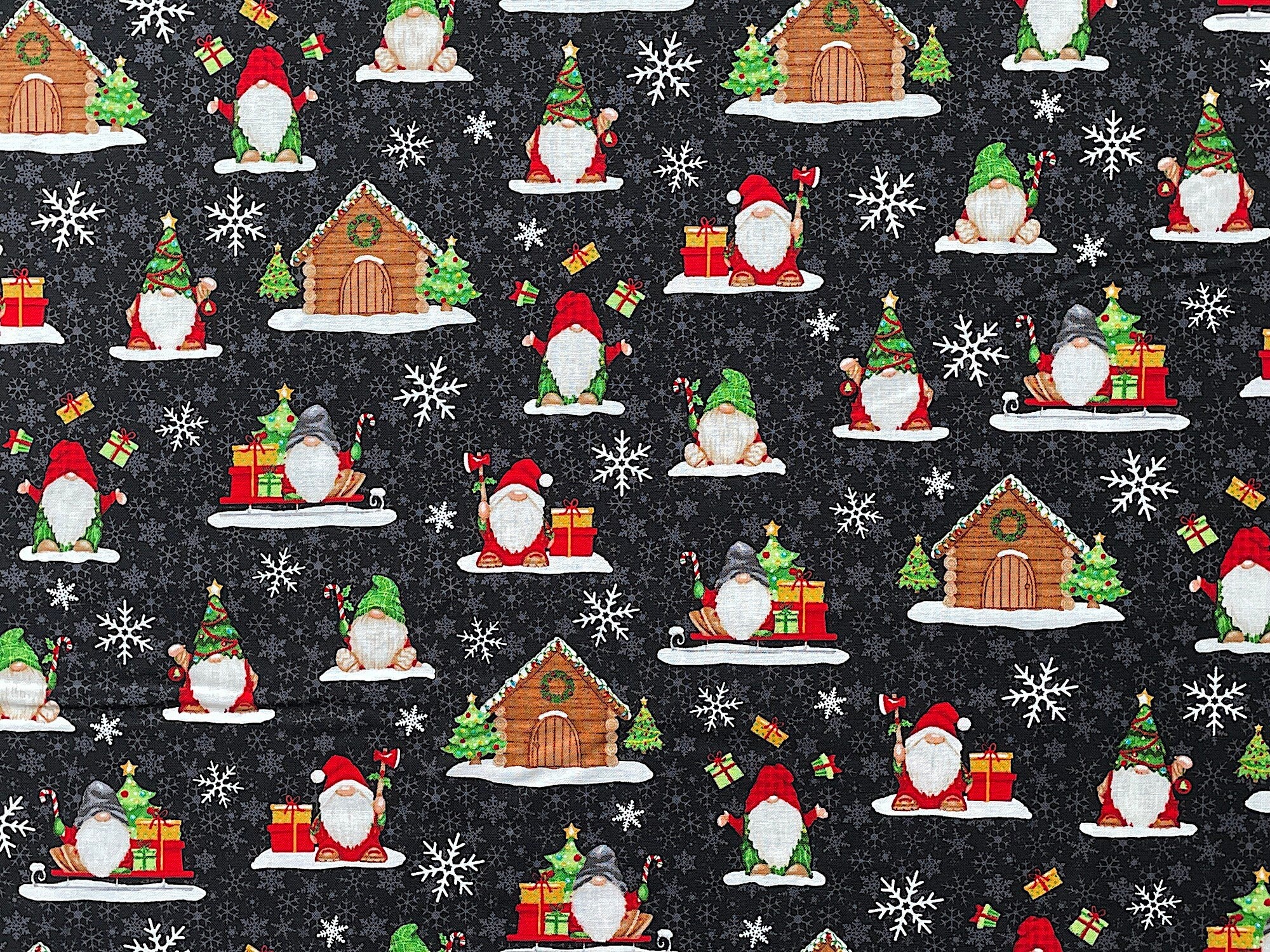 This black cotton fabric is covered with gnomes, gnome houses, Christmas trees, presents, snowflakes and more. The gnomes are tossing presents, holding candy canes or an ax. Snowflakes are sprinkled throughout the pattern.