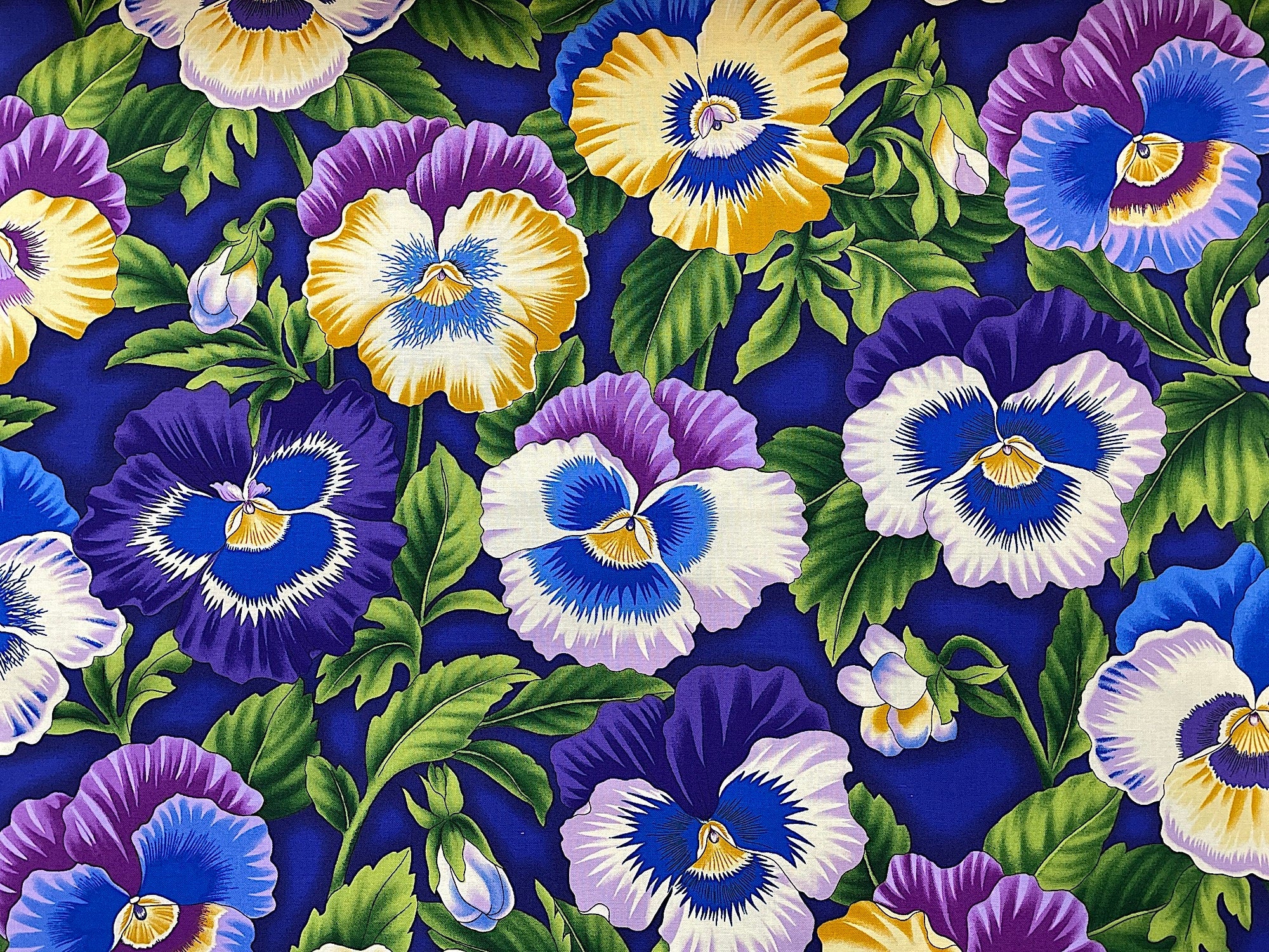 This cotton fabric is covered with purple, white and yellow pansies and green leaves.
