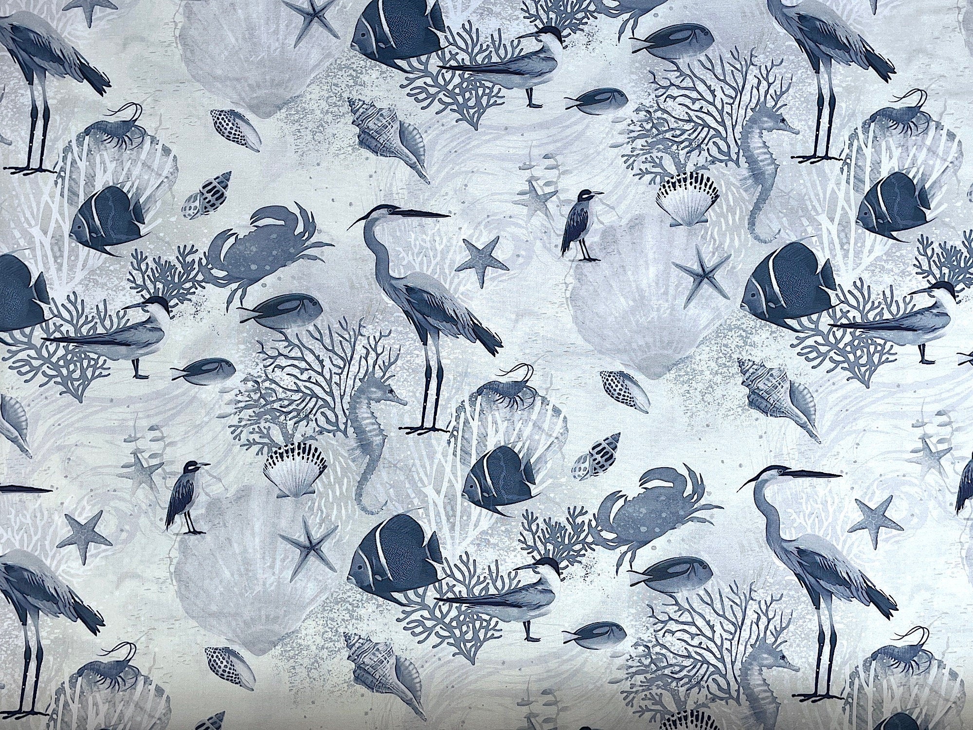 This fabric is called Sealife and is covered with blue fish, seashells, ocean plants, birds, seahorses, starfish and more. This fabric is part of the Seashell Wishes collection by Clothworks.