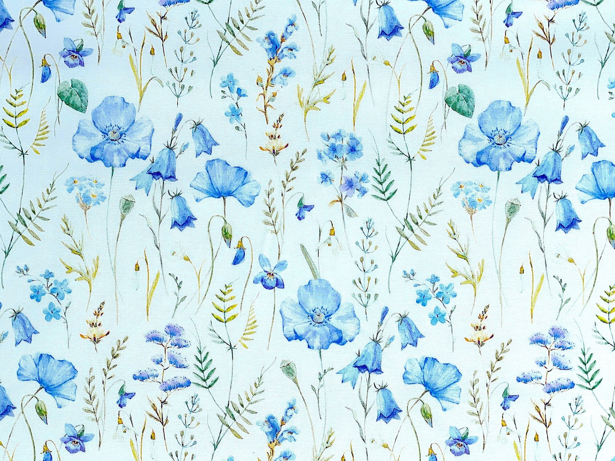 White cotton fabric covered with blue poppies.