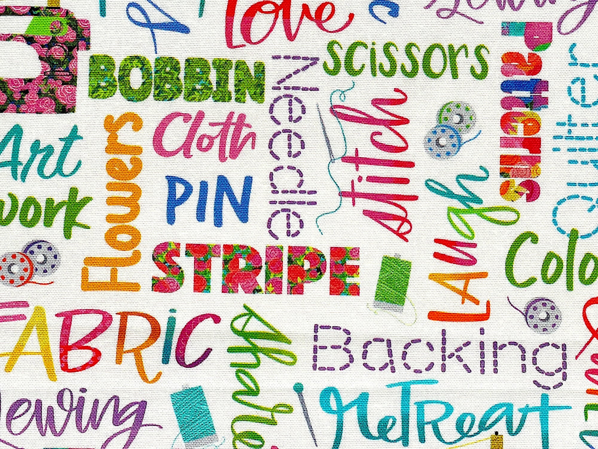 Close up of bobbins, thread and sayings such as stripe, flowers, retreat and more.