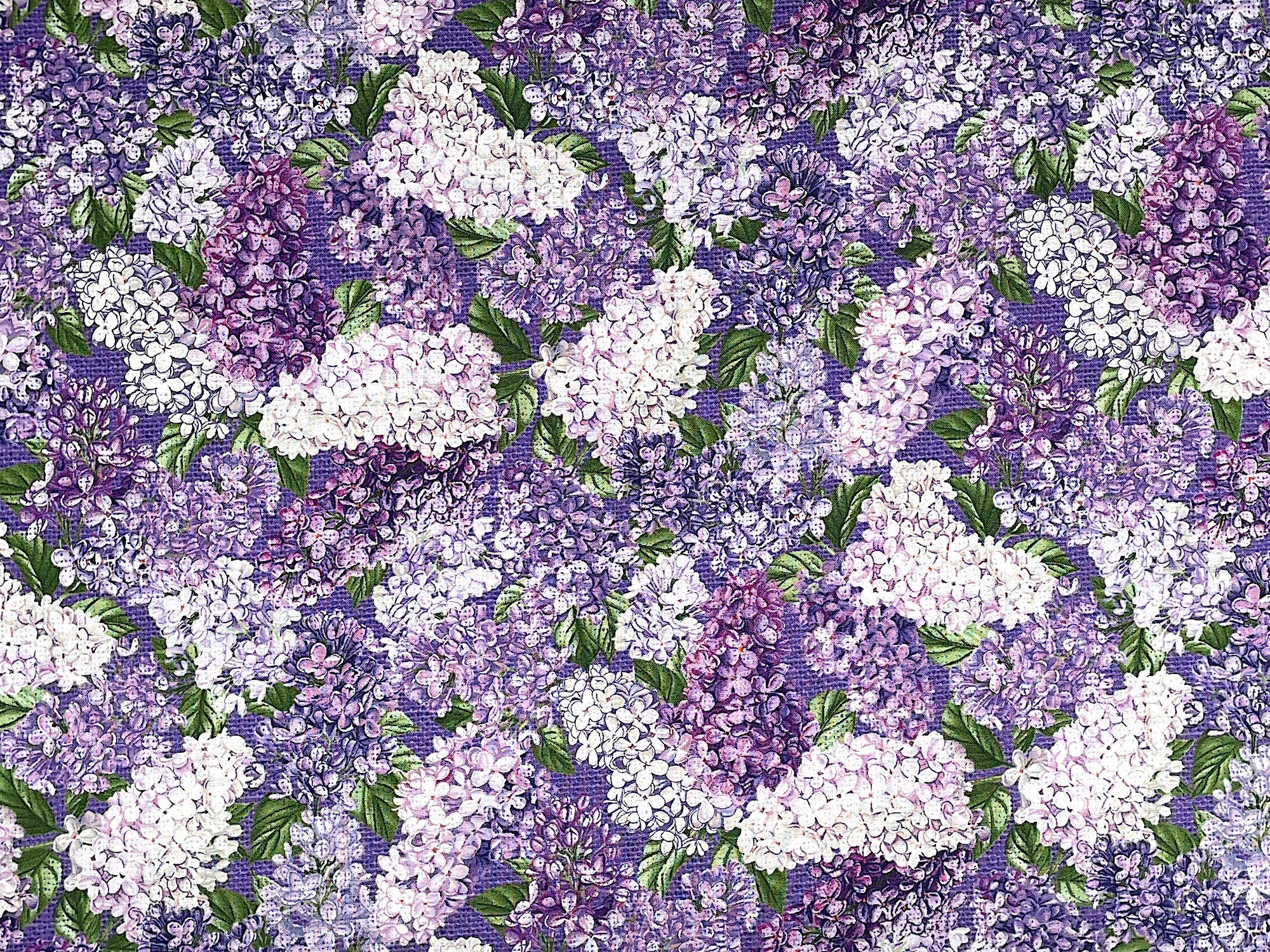 Purple cotton fabric covered with lilacs that are shades of purple and white.