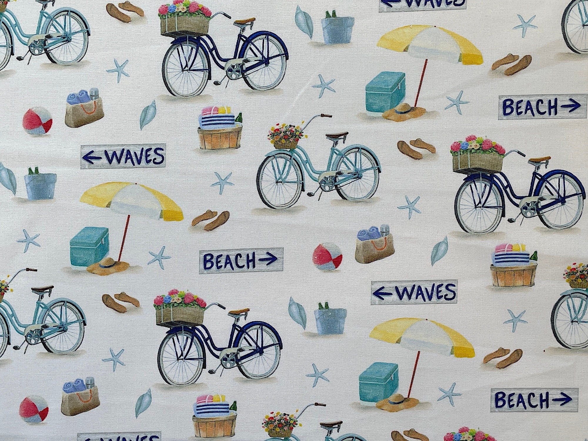 This fabric is part of the Beach Time collection by P&B Textiles. This cream fabric is covered with bicycles, beach umbrellas, beach balls, tote bags, coolers and more. There are Beach and Waves signs throughout the fabric. This fabric was designed by James Wiens