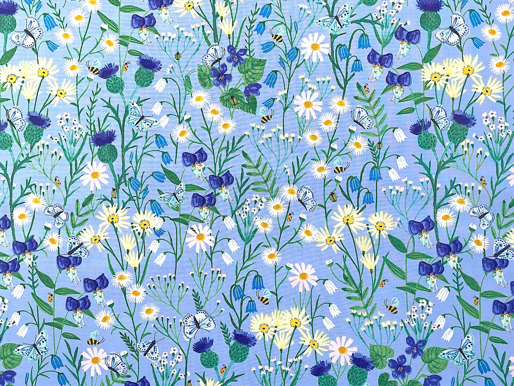 This fabric is part of the Springtime collection by Rebecca Jones. This periwinkle blue fabric is covered with white, yellow and blue flowers. There are also bees and butterflies throughout the pattern.