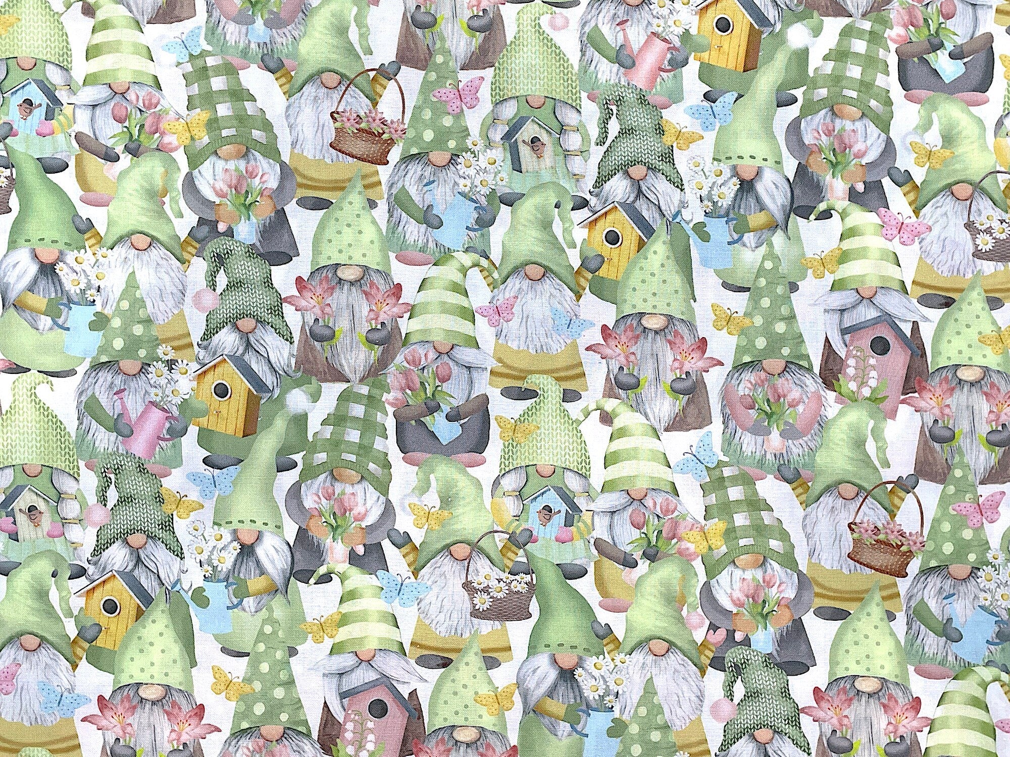 This cotton fabric is covered with gnomes, bird houses and flowers. The gnomes are holding bird houses, tulips and daisies.
