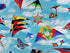 Close up of kites that are black, red, yellow, blue and green.