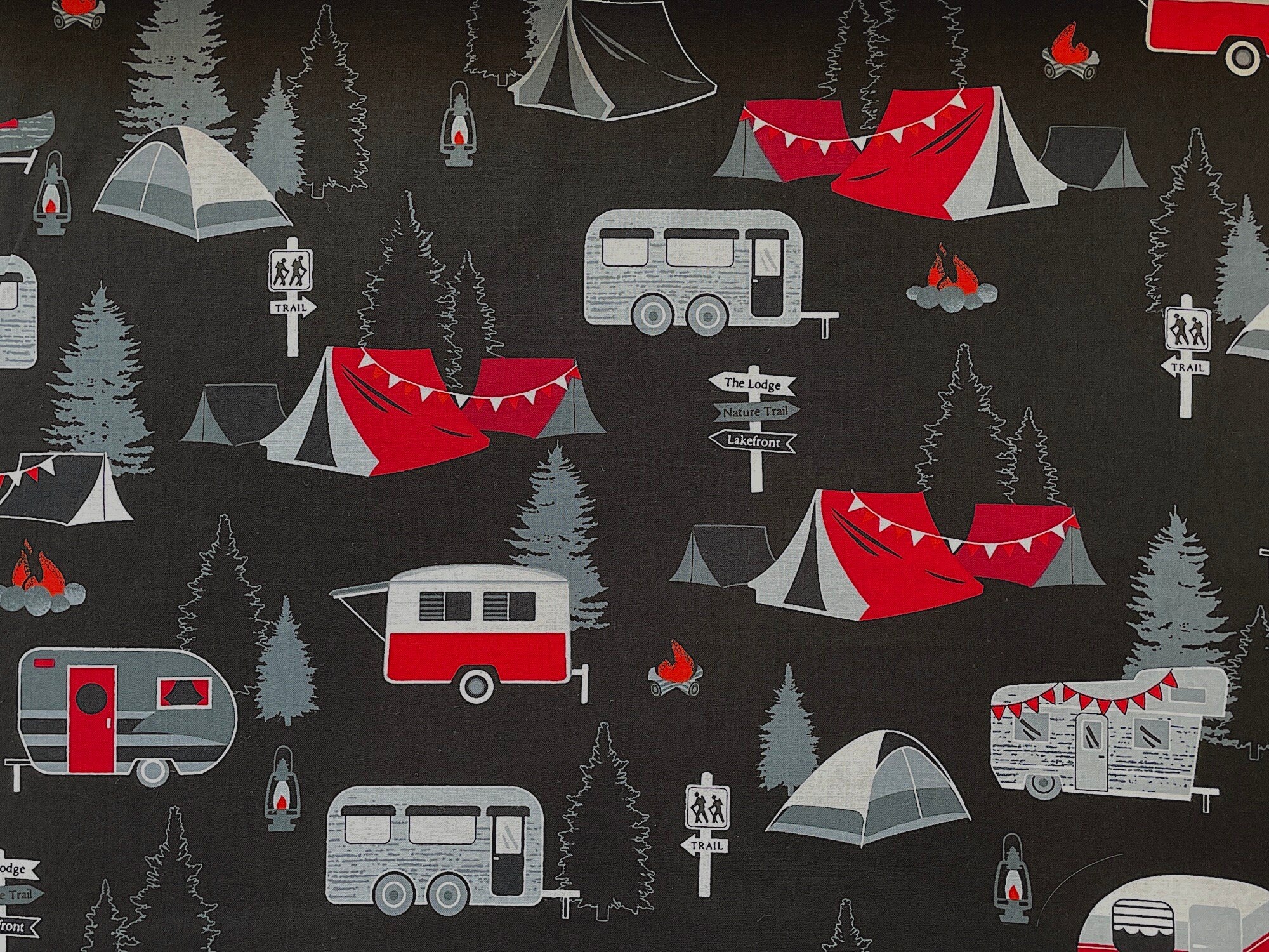 This fabric is called Gone Camping and is part of the Great Outdoors collection by Kanvas Studio. This black, fabric is covered with travel trailers, tents, campfires and trees. Directional signs say trail, the lodge, nature trail and lakefront. 