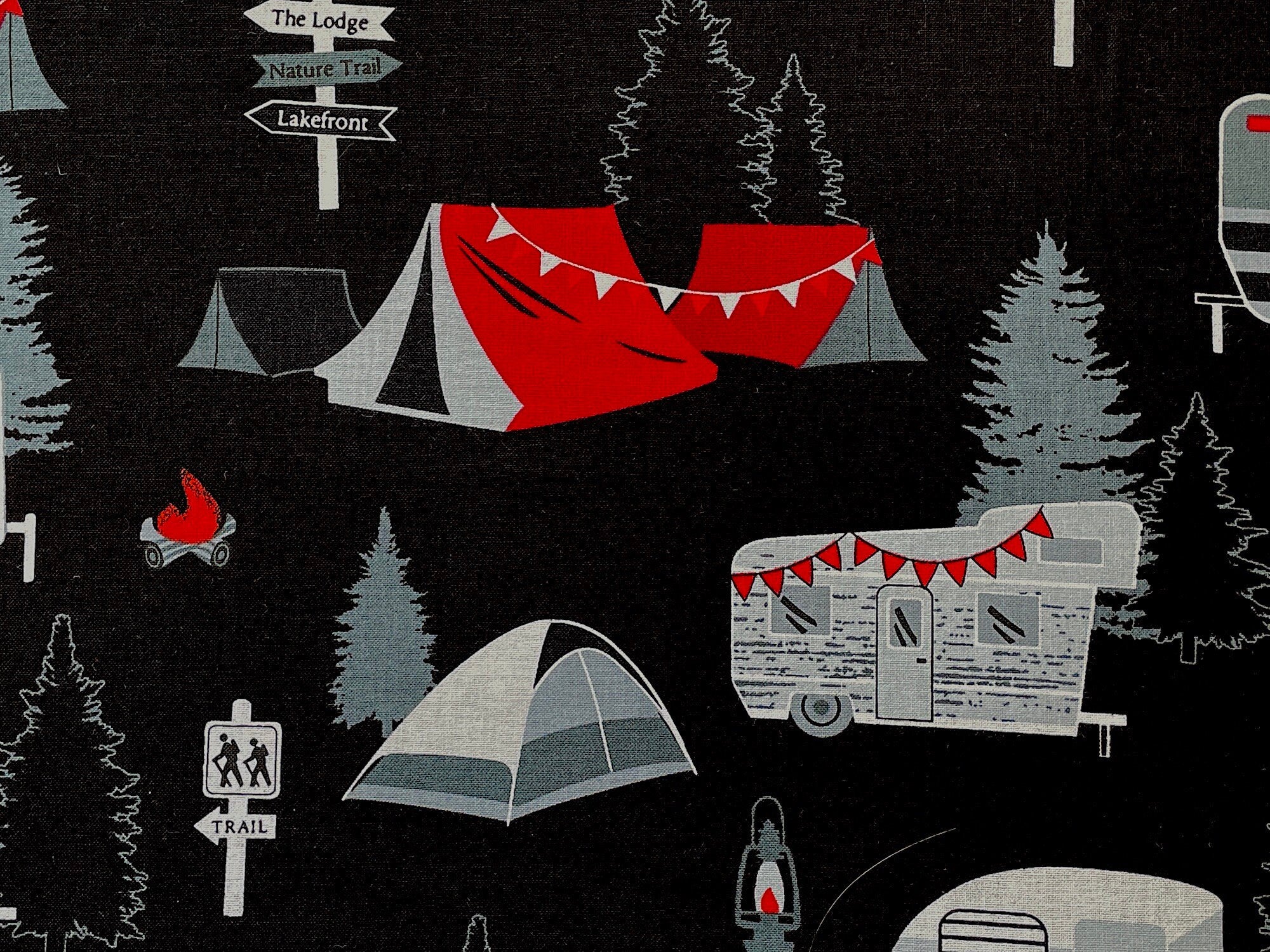 Close up of red, white and black tents and trees.