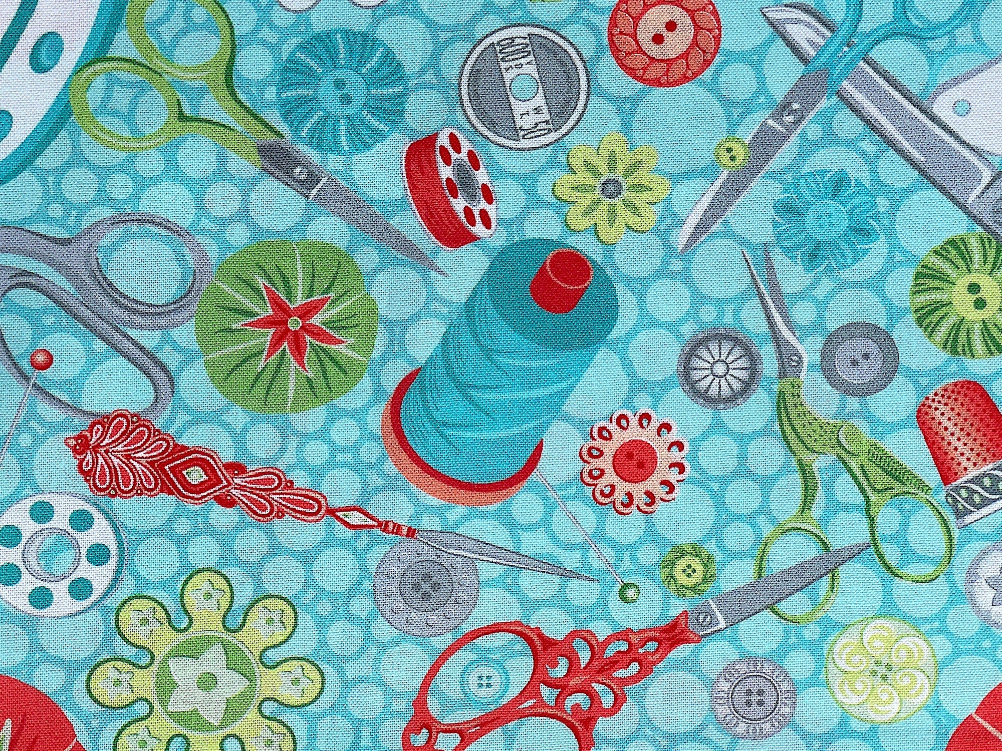 Close up of thread, pin cushions, scissors, buttons and more.