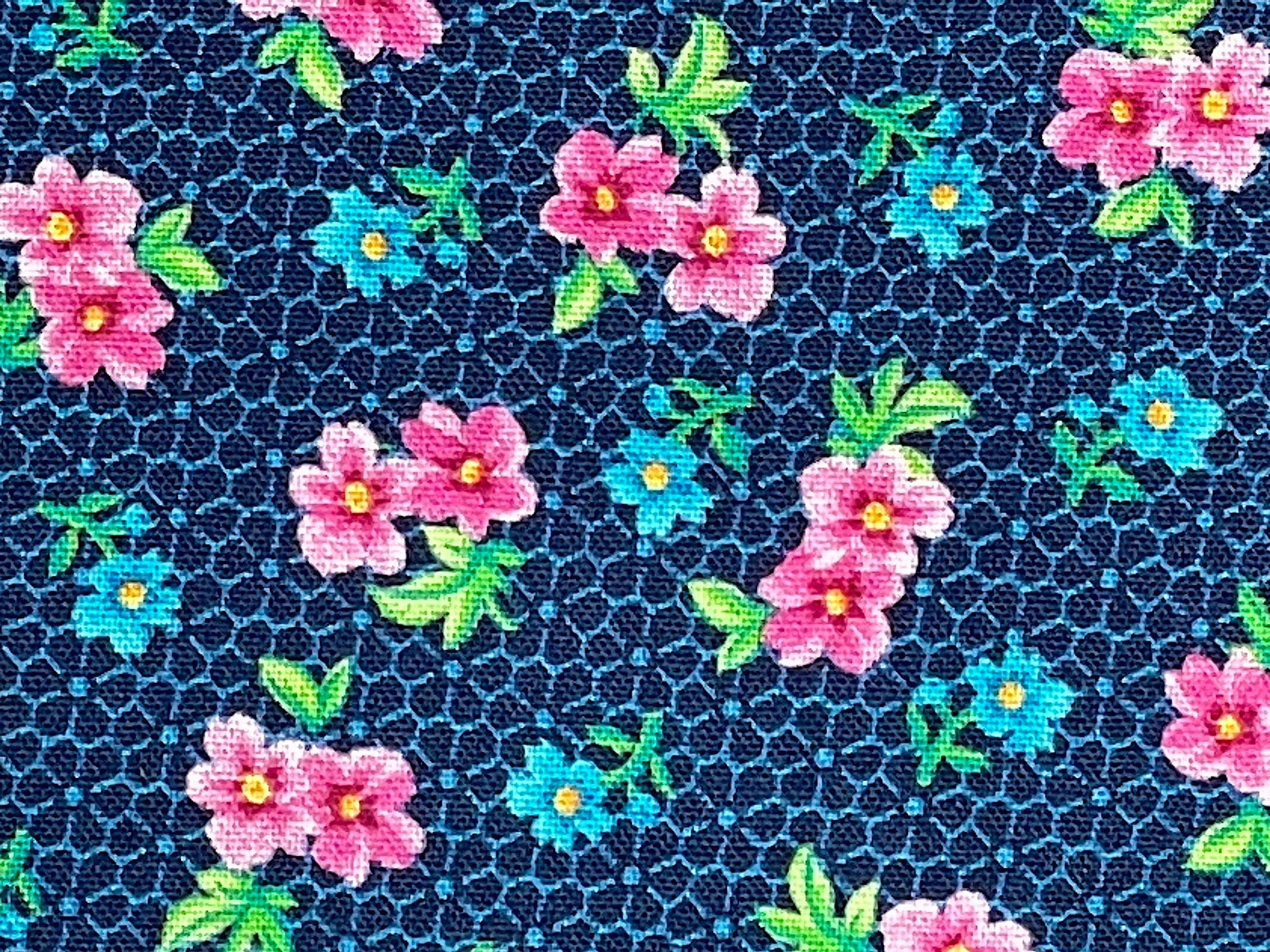 Blue fabric covered with pink and blue flowers and green leaves.
