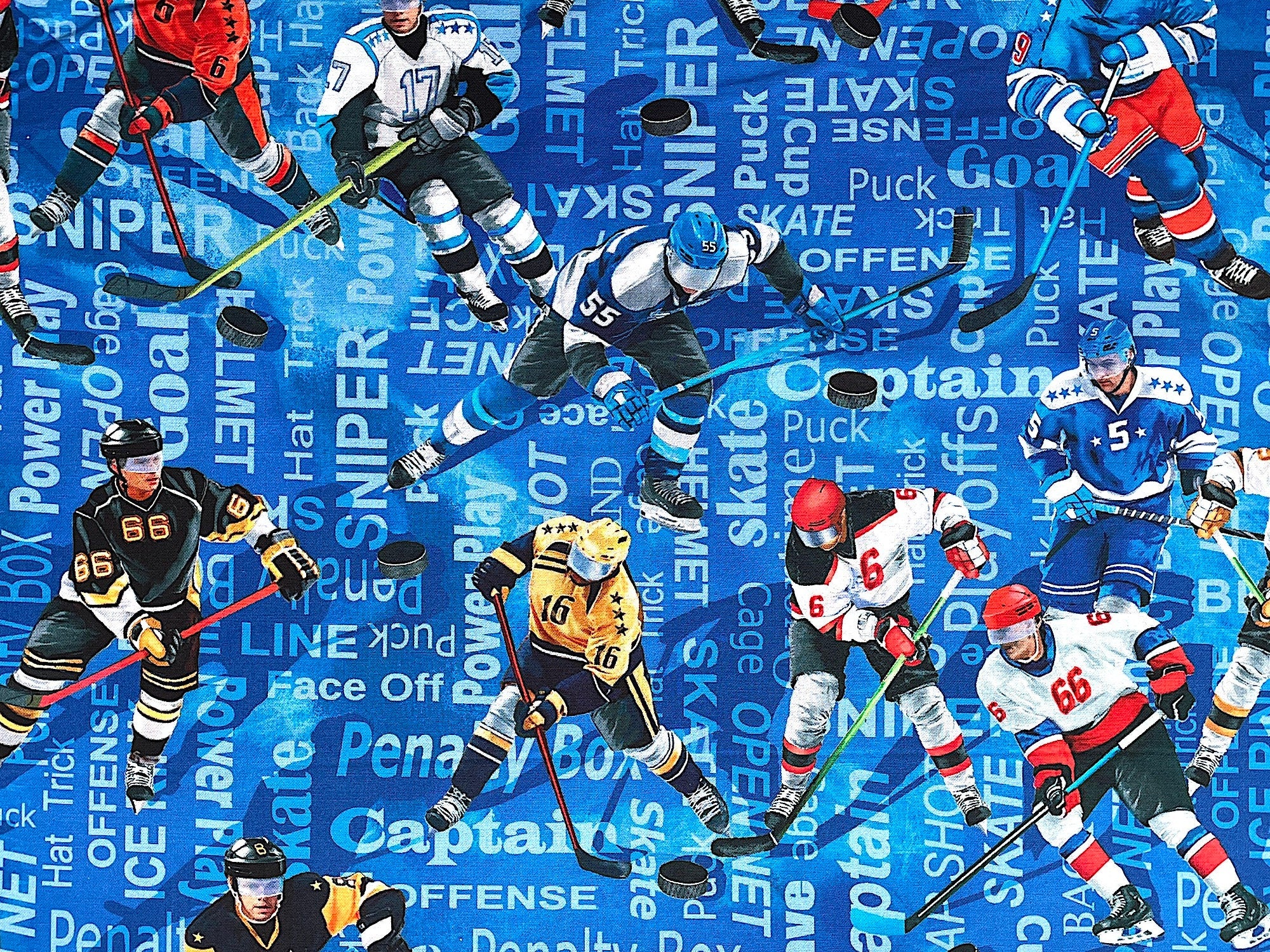 This fabric is part of the Hat Trick collection by Kanvas Studio. This blue cotton fabric is covered with hockey players. The background is covered with hockey sayings such as hat, helmet, sniper, goal skate and more.