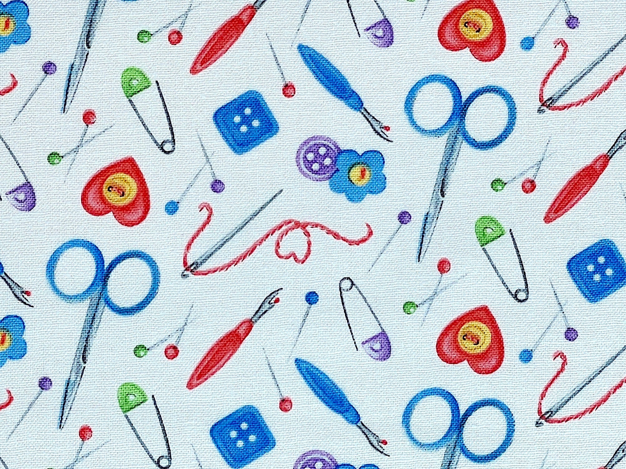 Close up of scissors, seam rippers, safety pins, buttons and more.