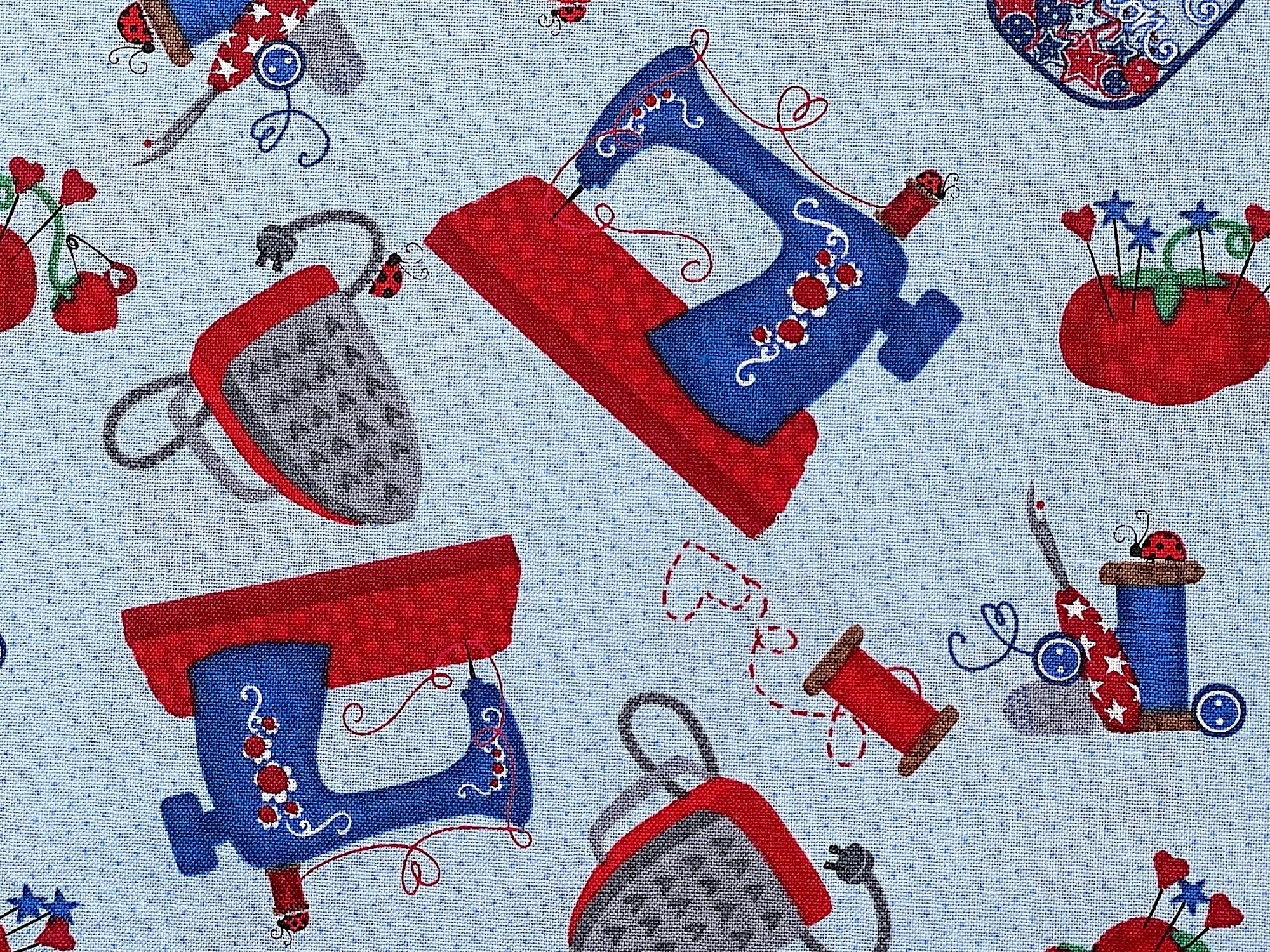 Close up of a blue and red sewing machine and a blue and grey iron.
