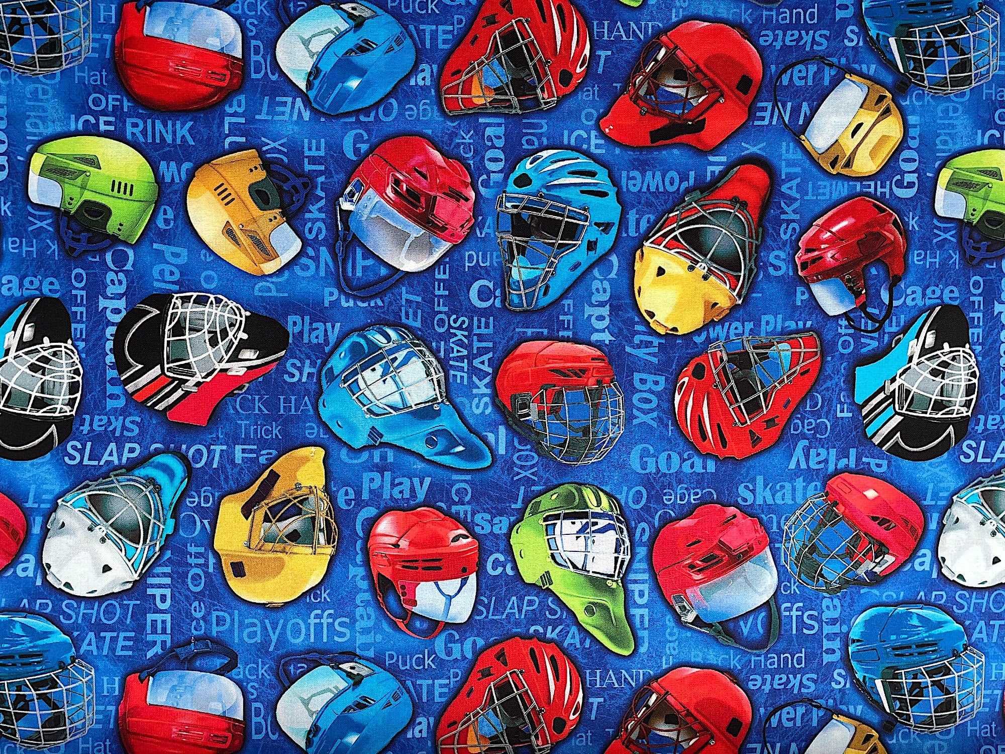 This fabric is part of the Hat Trick collection by Kanvas Studio. This blue cotton fabric is covered with red, blue yellow and green hockey helmets. The background is covered with hockey sayings such as hat, helmet, sniper, goal skate and more.