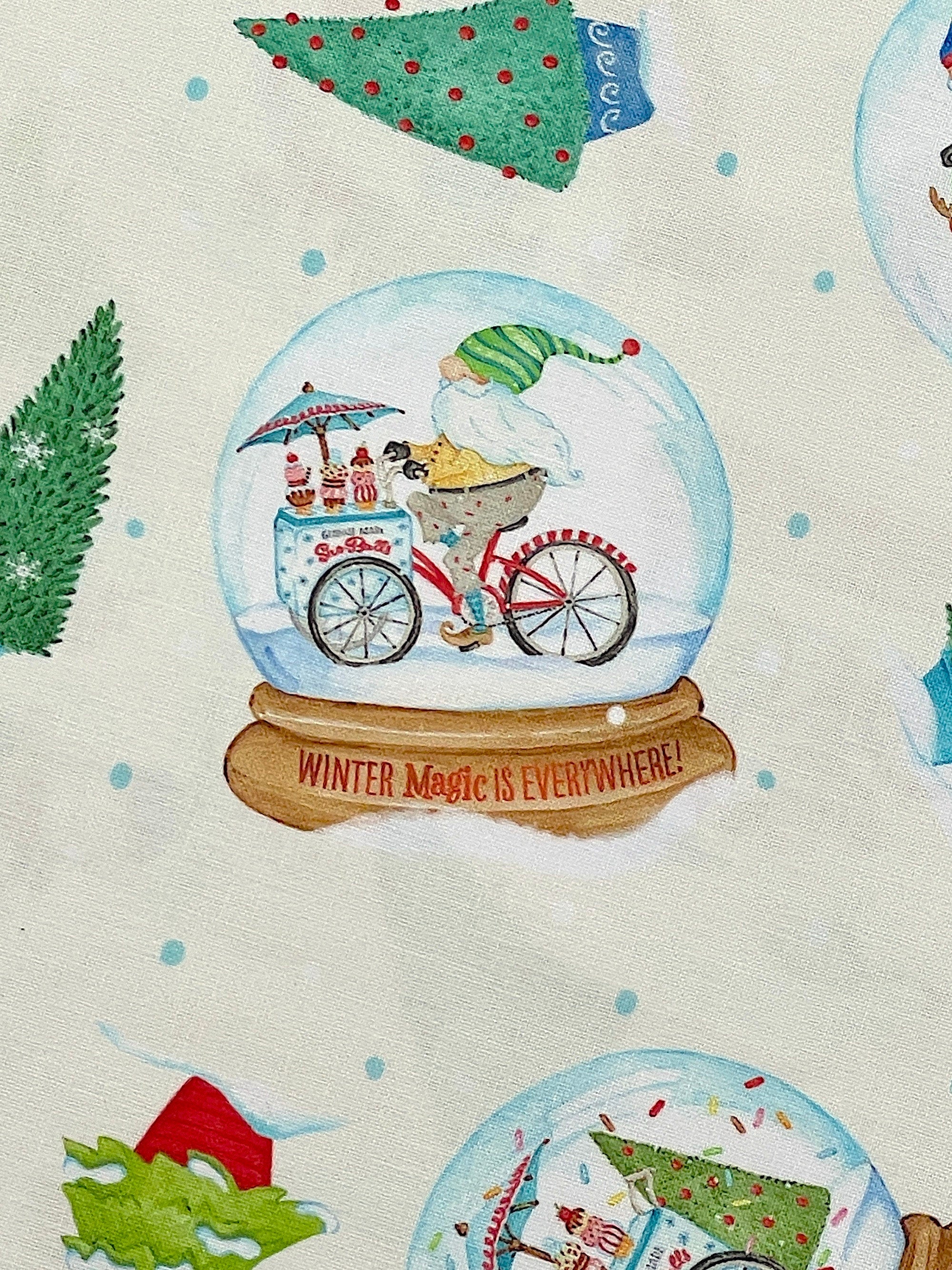 Close up of a gnome riding a bike inside of a snow globe.
