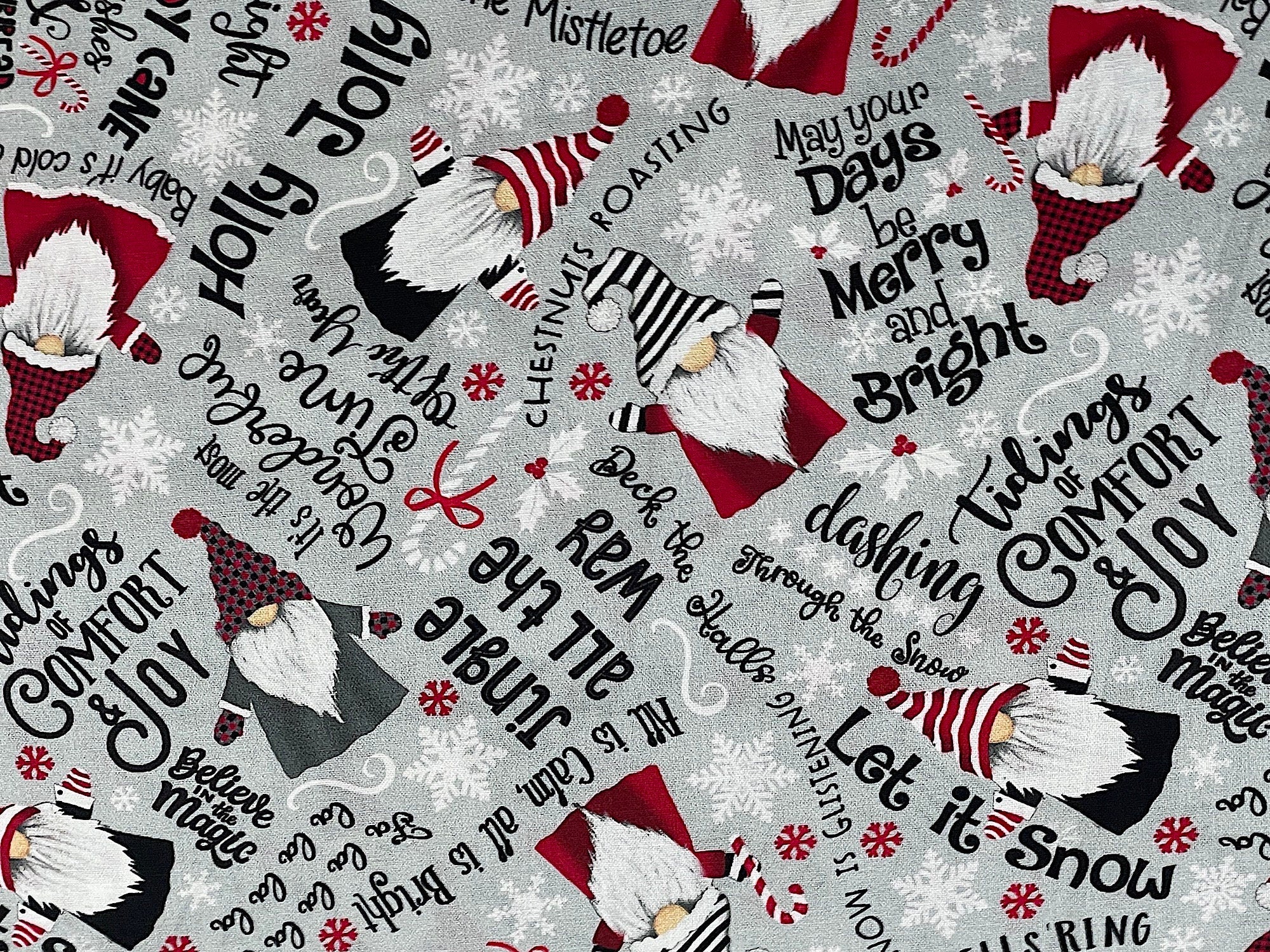 This grey fabric is called gnomes and Christmas wishes text and is covered with gnomes and sayings. Some of the sayings are jingle all the way, tidings of comfort and joy, holly jolly, chestnuts roasting and more