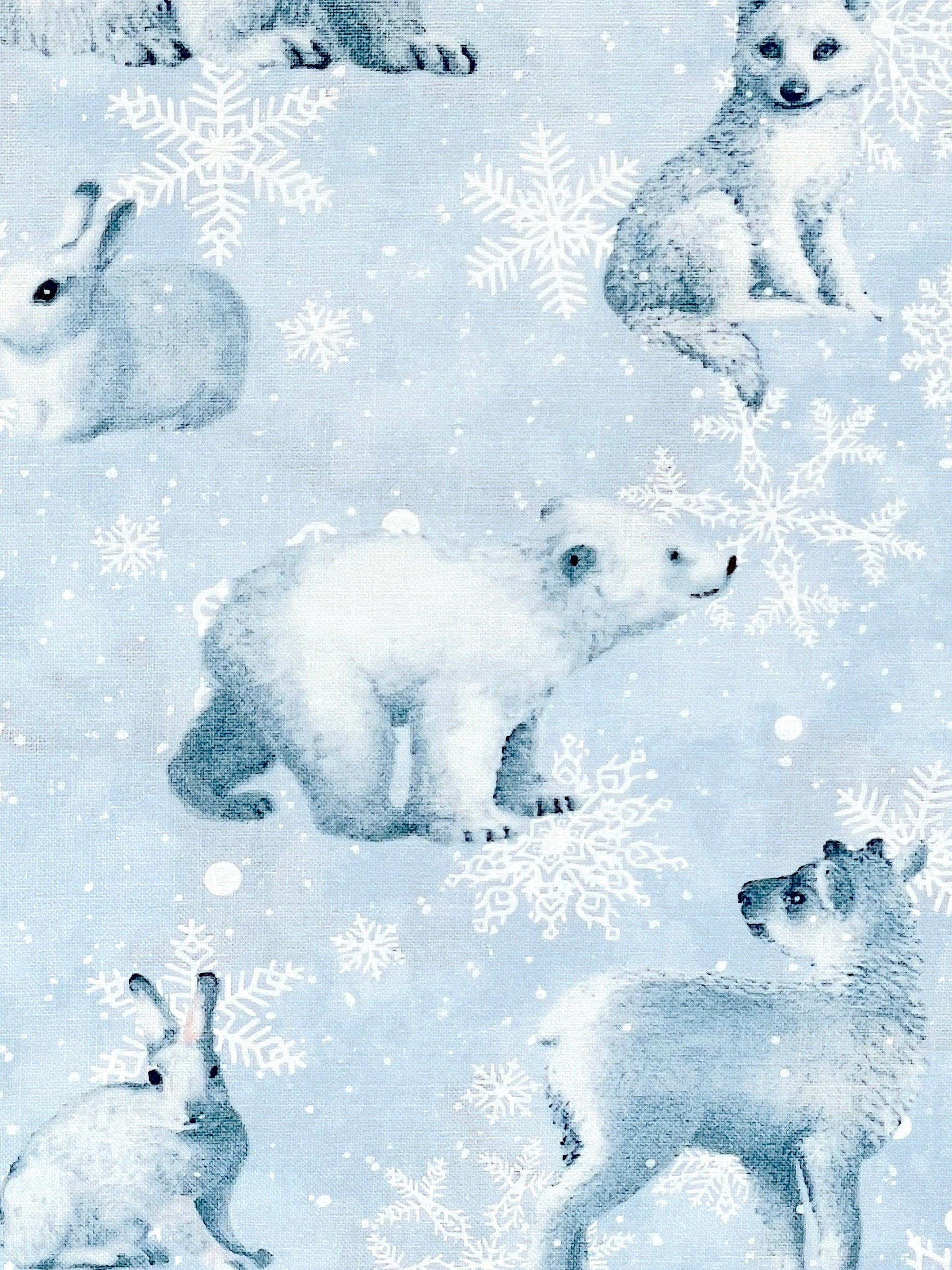 Close up of light blue fabric with a bear and snowflakes.