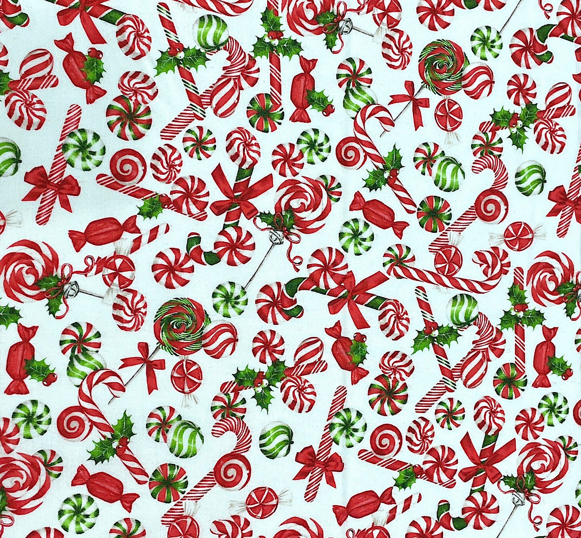 This fabric is called Peppermint Candy. This white fabric is covered with red, white and green peppermint candies. Some of the candies are candy canes, lollipops and candy pieces.