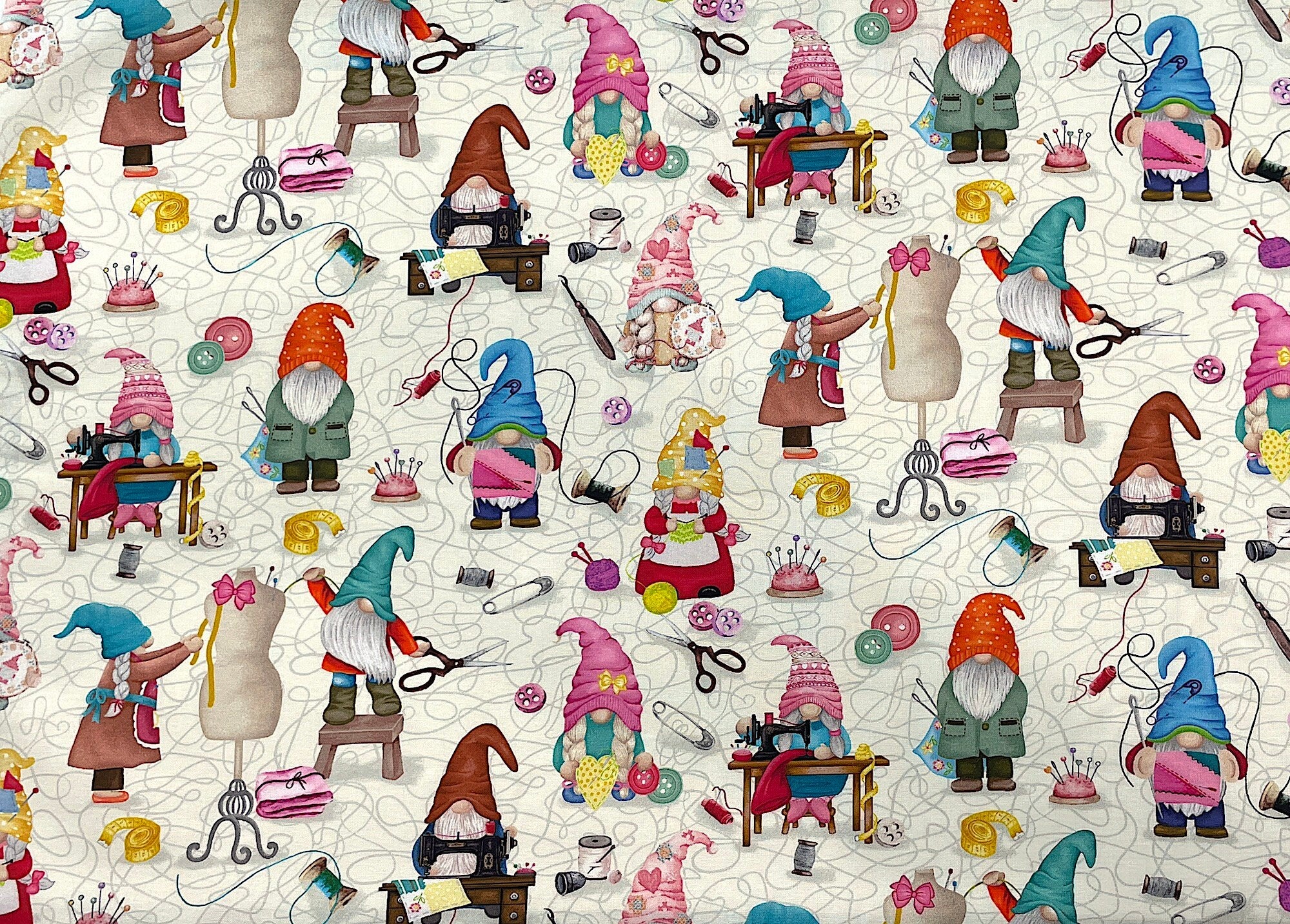 This off white fabric is covered with sewing gnomes. the gnomes are at the sewing machine, holding scissors, knitting and more. There are also spools of thread, pincushions, seam rippers, buttons and more