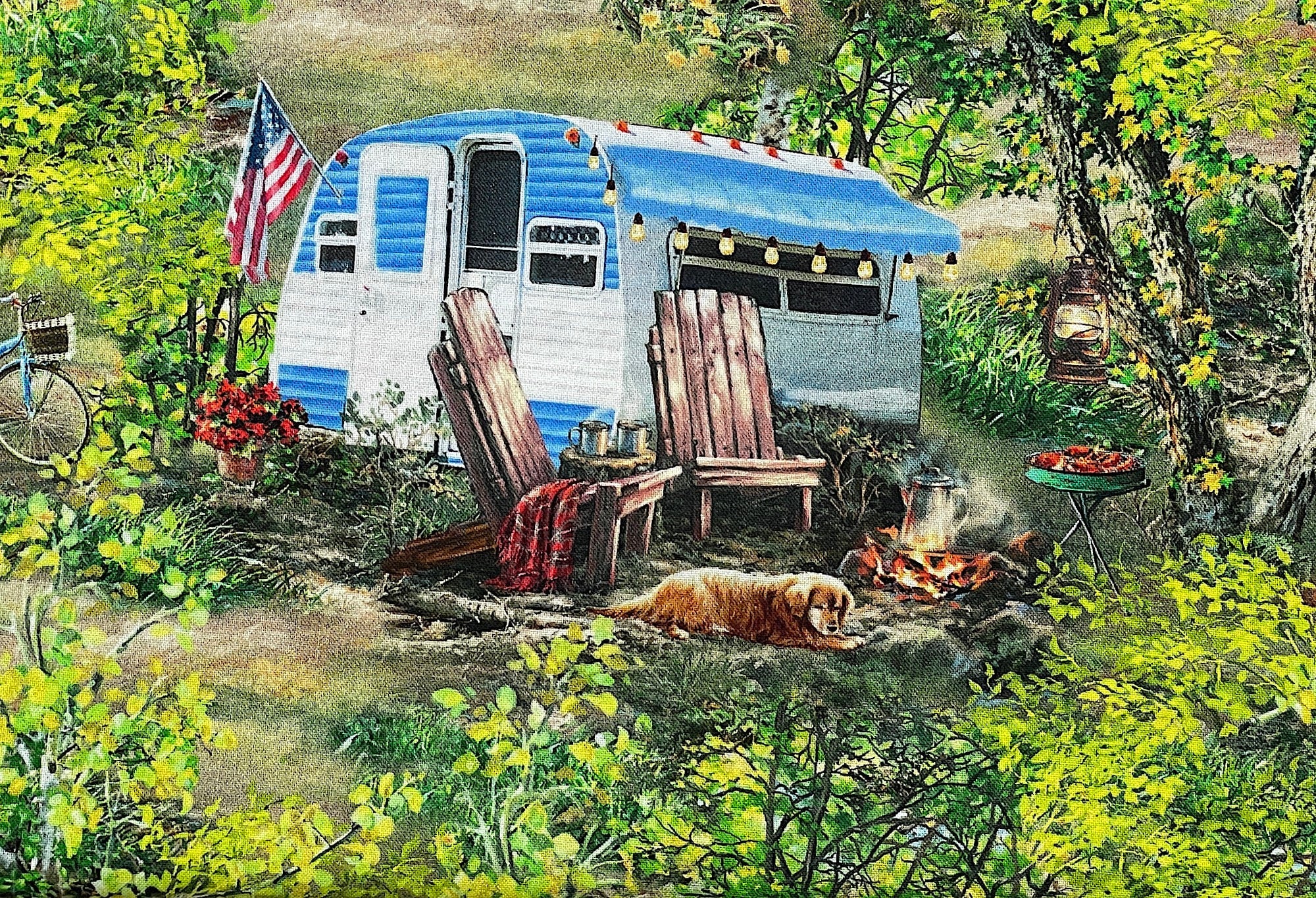 Close up of a blue and white travel trailer amongst the trees. The dog is laying by the fire pit that has coffee brewing on it