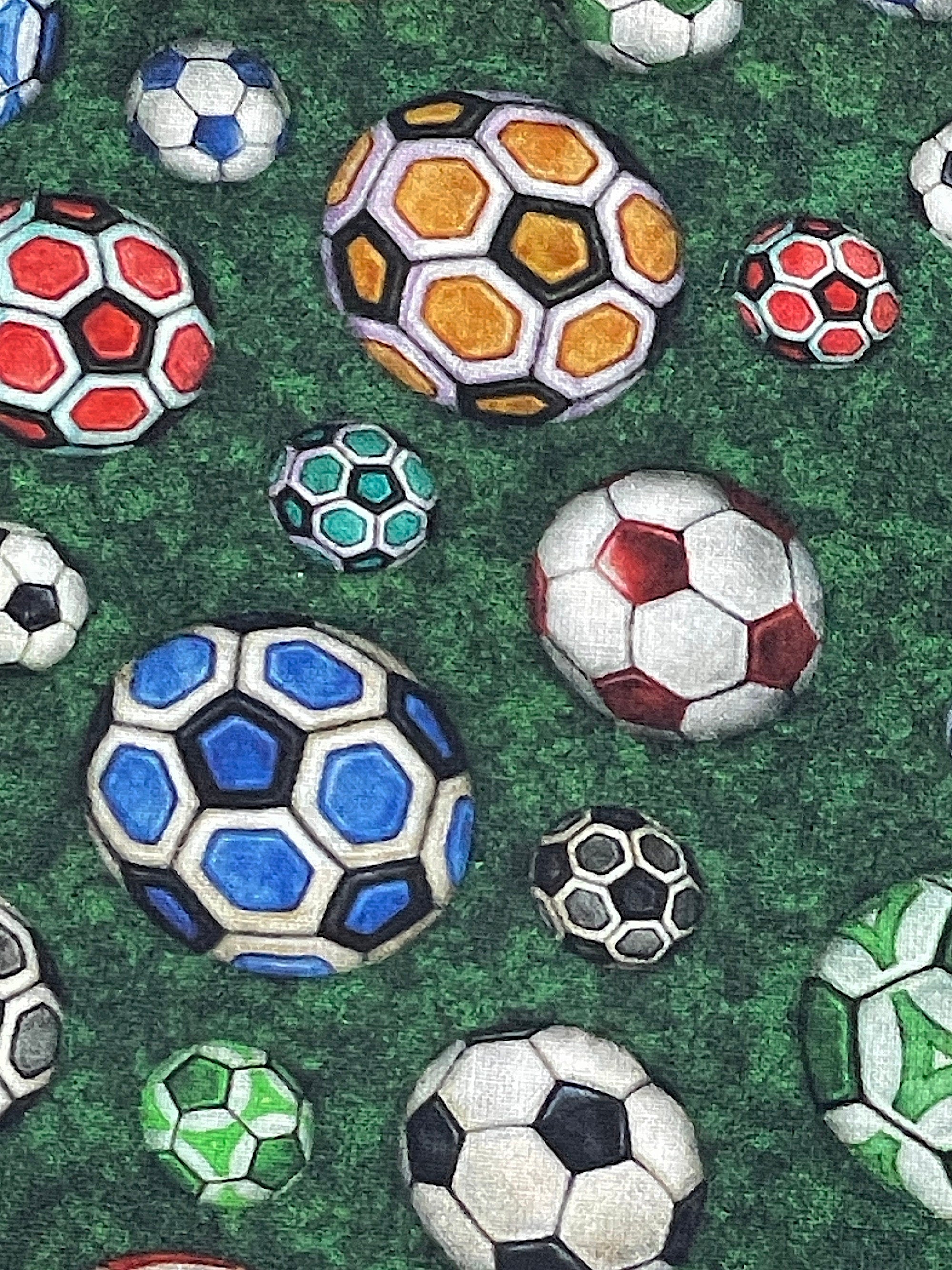 Close up of soccer balls on a green background.