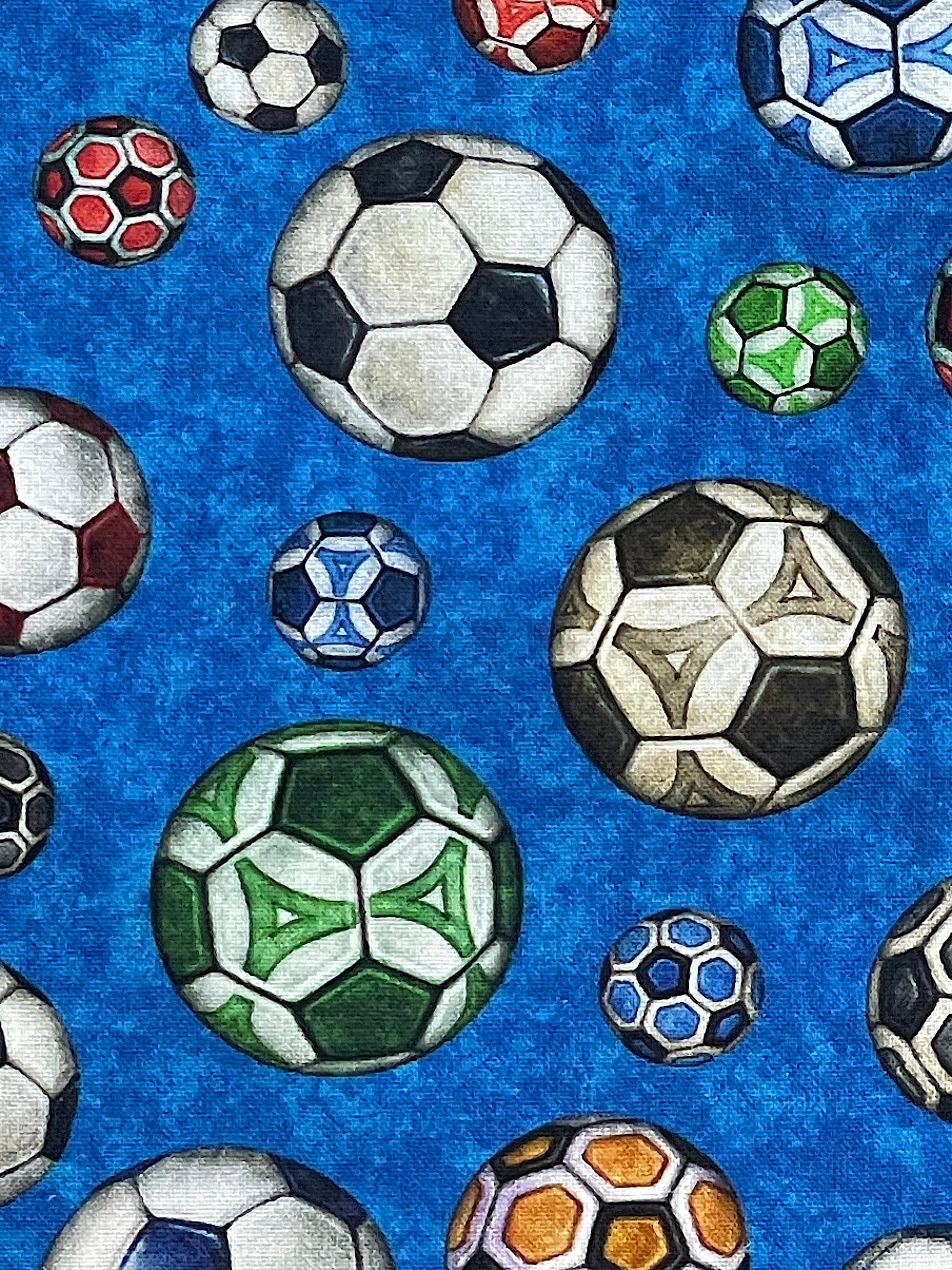 Blue cotton fabric covered with green, glue, black and white soccer balls.