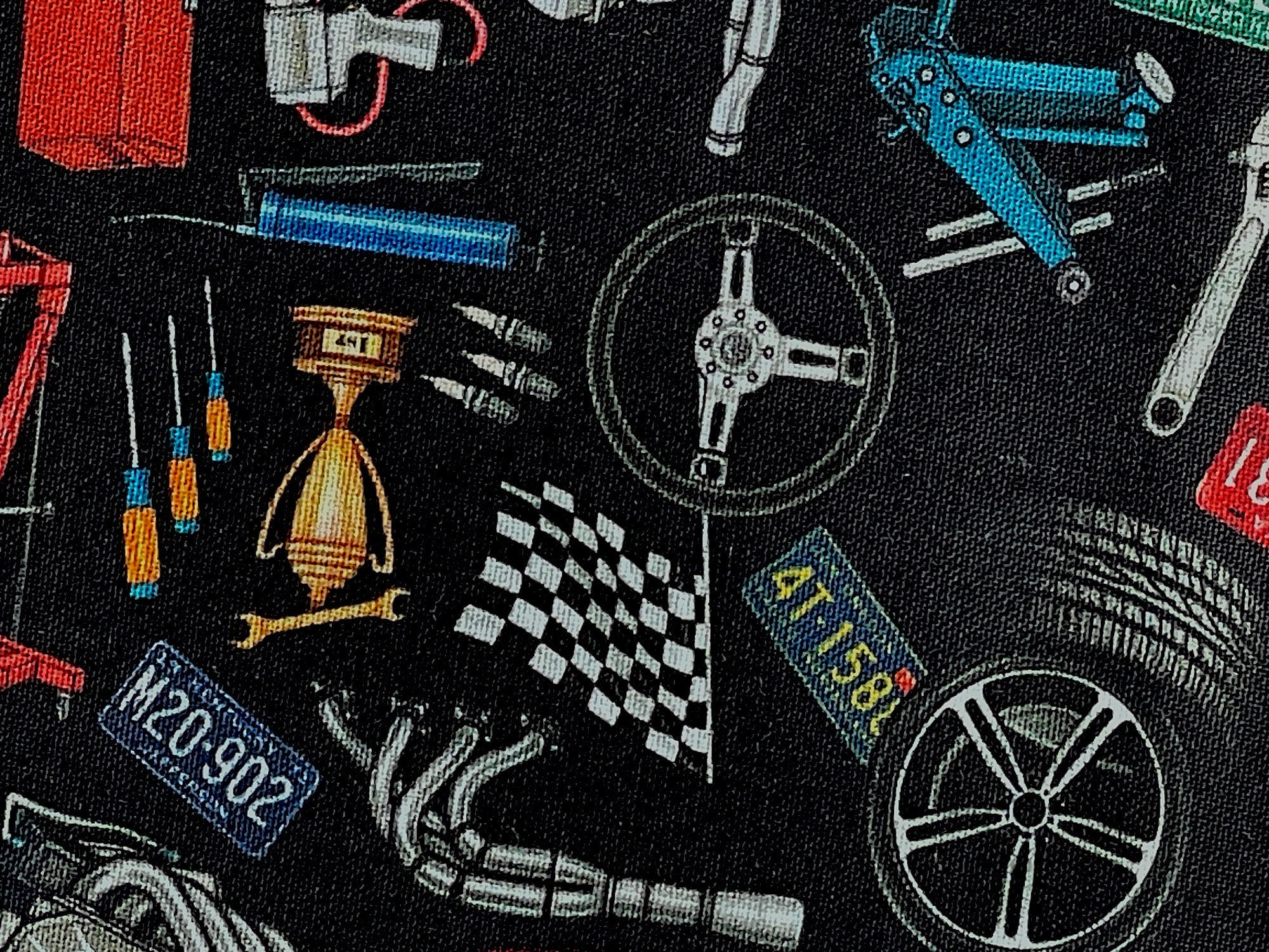 Close up of steering wheel, tires, license plates, screwdriver and more.