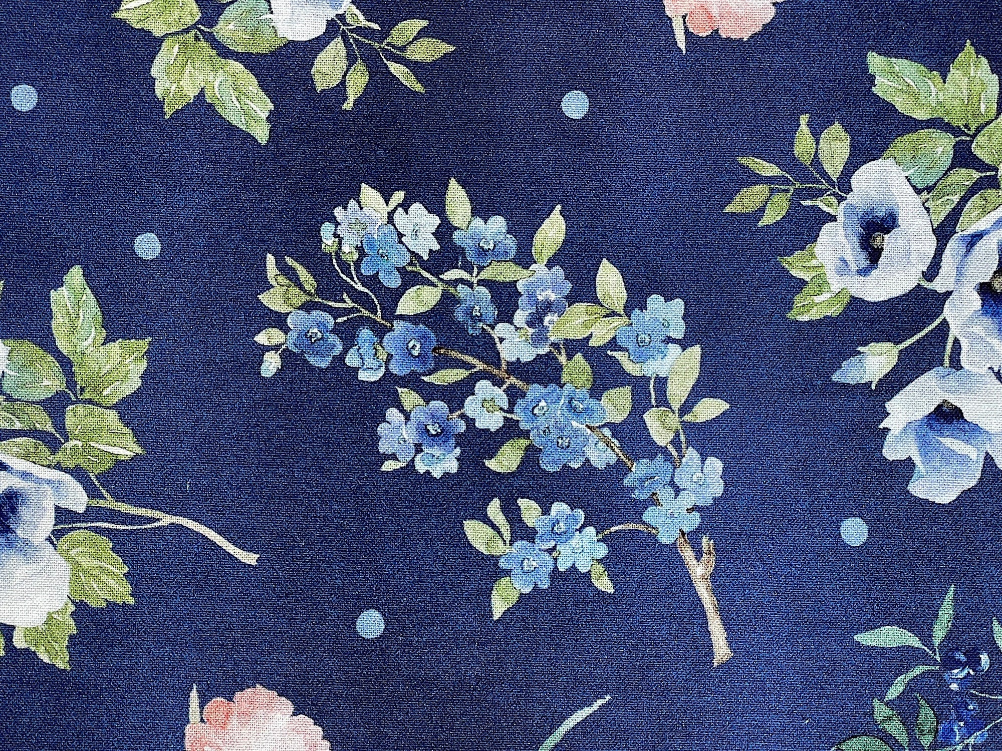 This fabric is part of the Indigo Petals collection by Beth Grove. This blue fabric is covered with blue and pink flowers, green leaves and blue butterflies.