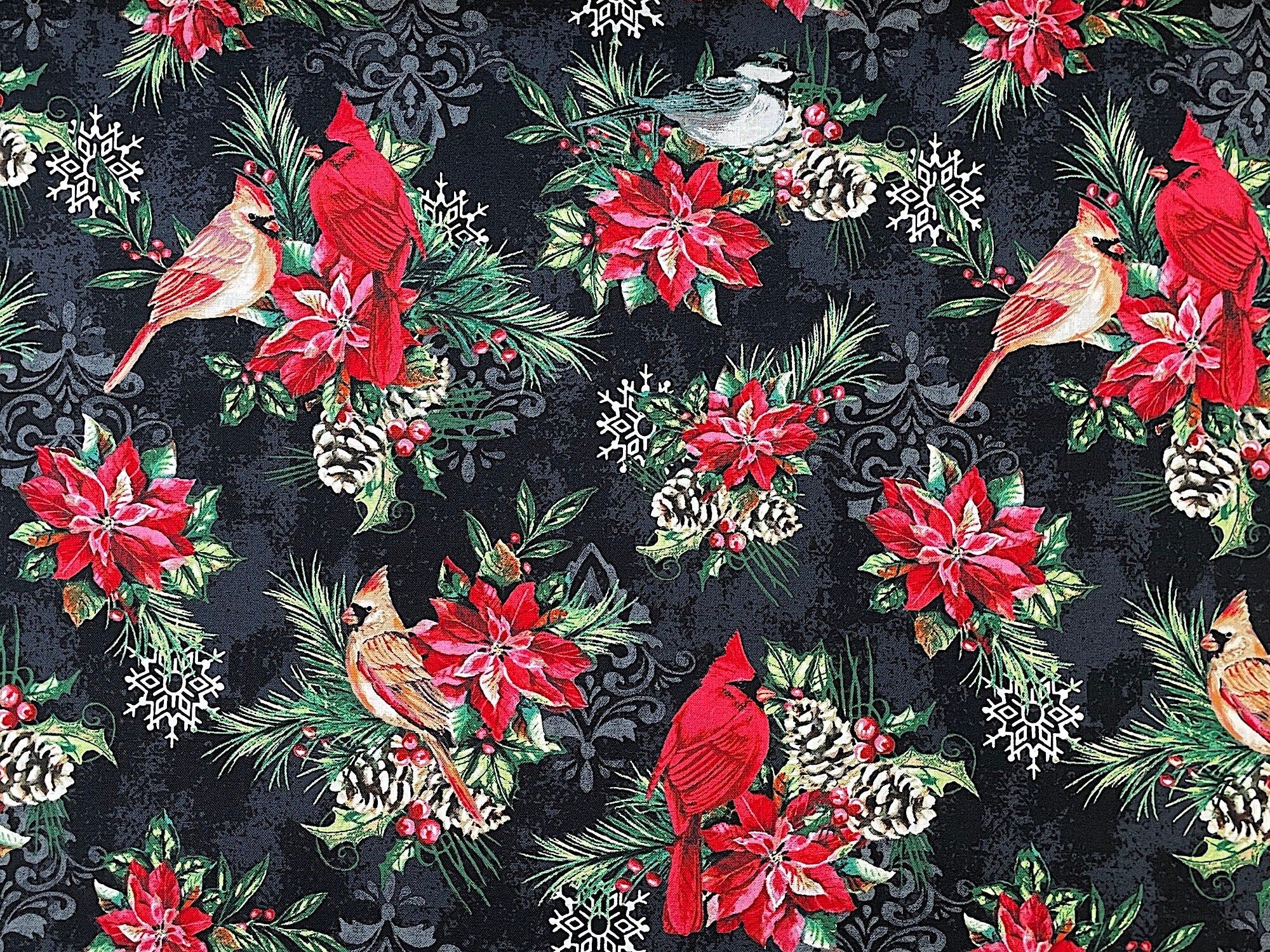 This fabric is part of the Holiday Greetings collection by Jean Plout. This Black colored fabric is covered with red cardinals sitting on branches made up of leaves, pine cones, poinsettias and leaves.