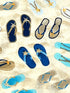 Close up of flip flops in the sand.
