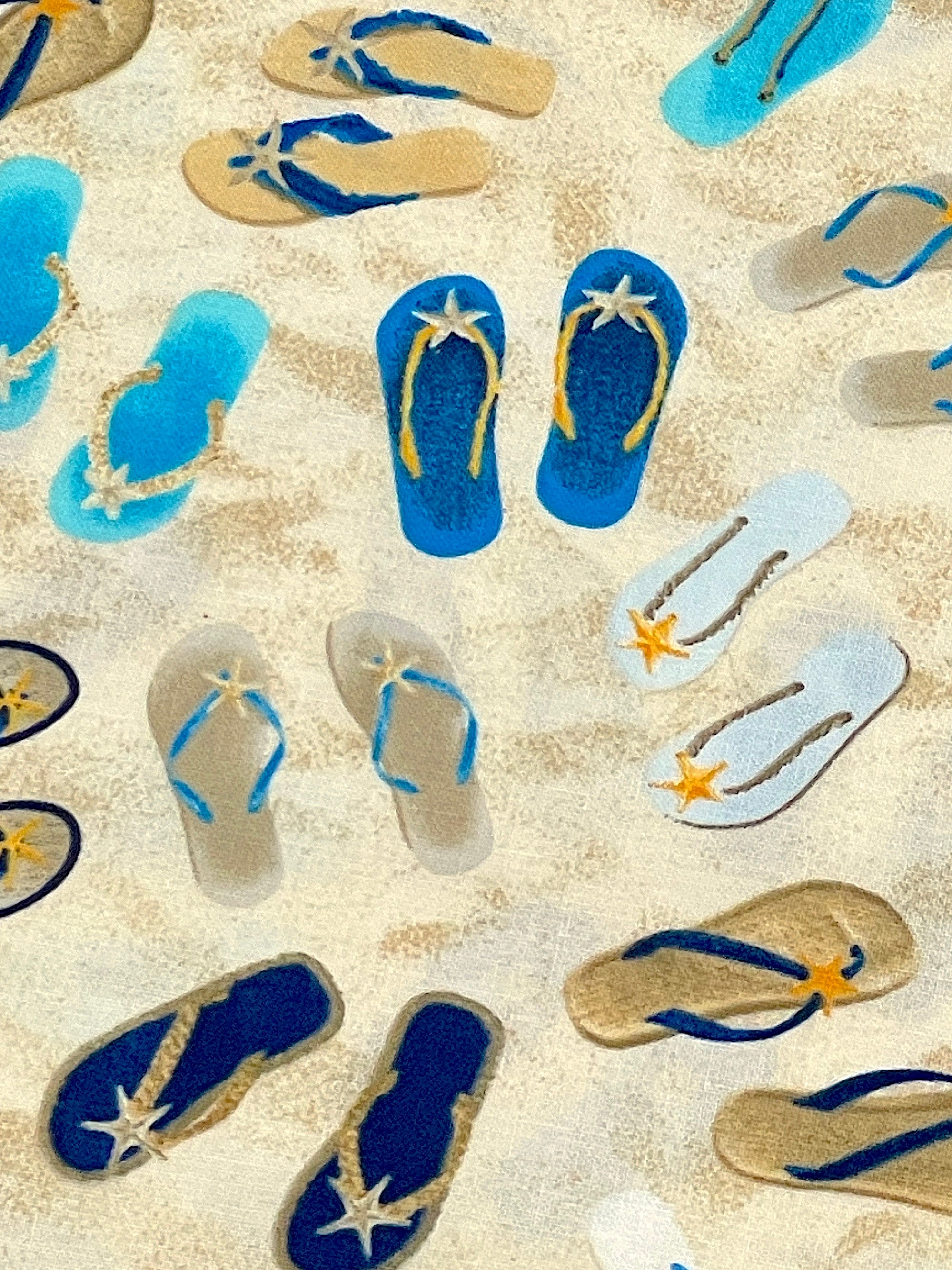 Close up of flip flops on the sand.